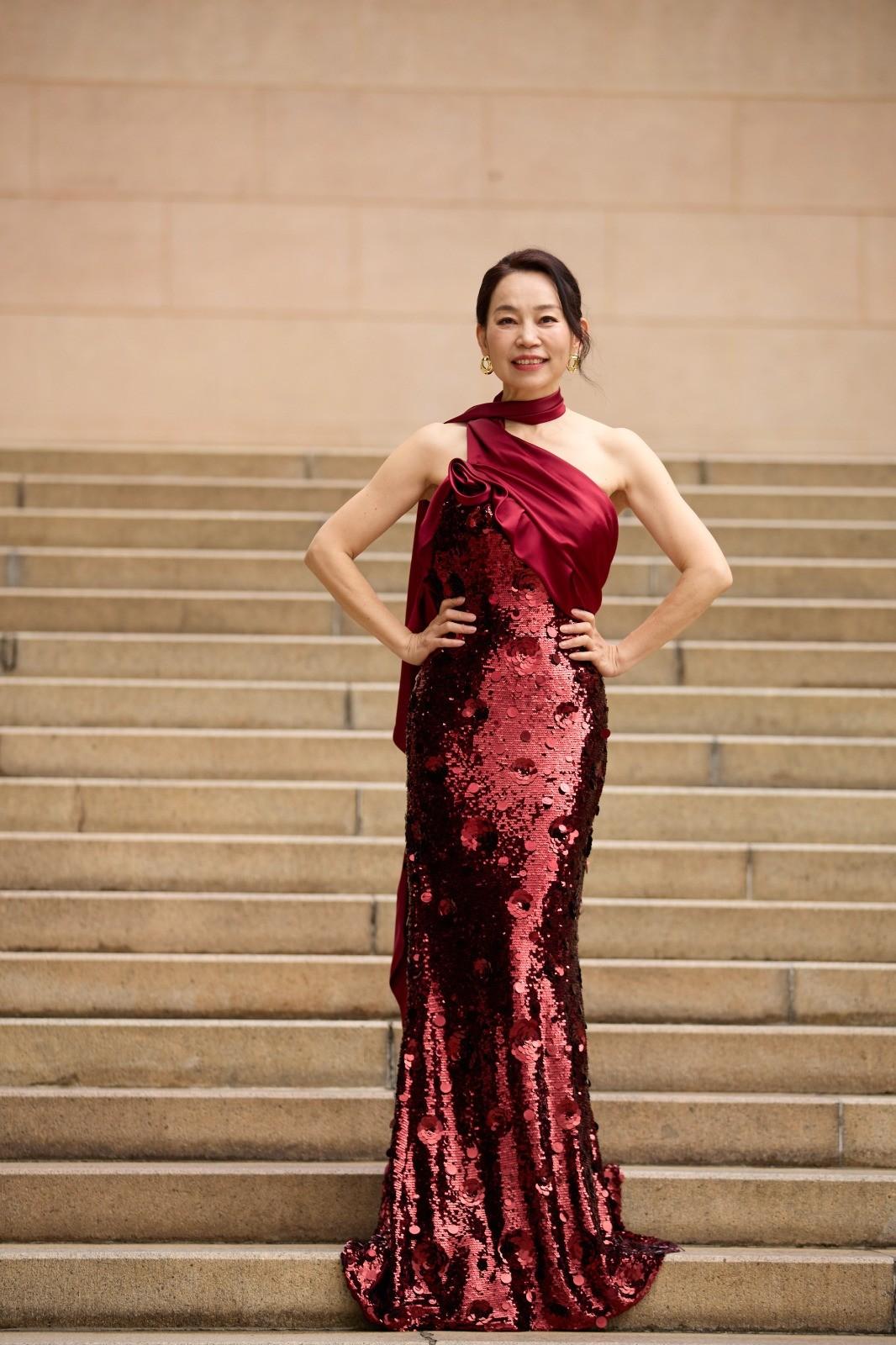 Ping Yan at leadership event wearing red evening gown and representing global business excellence